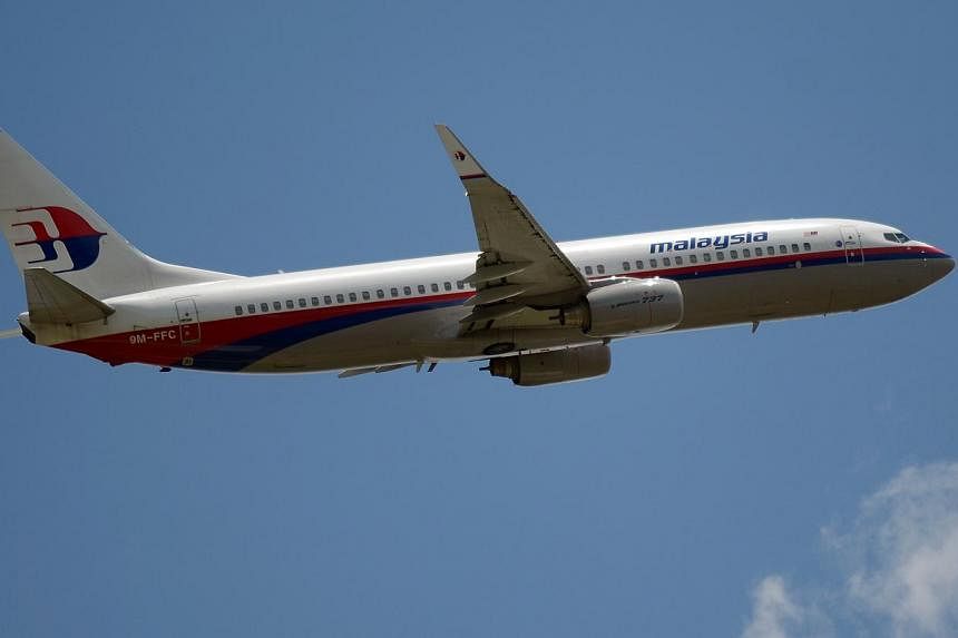 A file photo taken on March 18, 2013 shows a Malaysia Airlines Boeing 737 plane flying over the Sukarno-Hatta airport in Tangerang. -- PHOTO: AFP