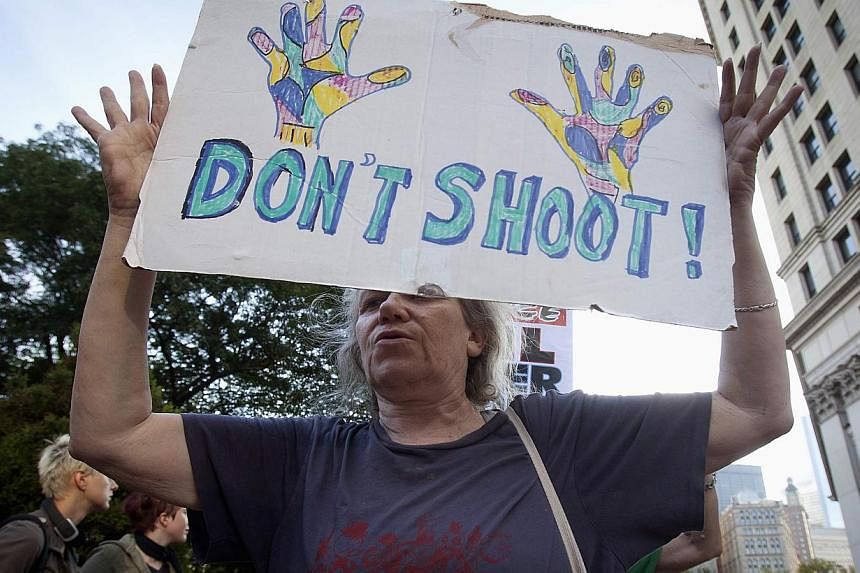 A protester carries a "Don't Shoot" sign as she participates in a protest against the police in Ferguson, Missouri, in the Manhattan borough of New York. -- PHOTO: REUTERS&nbsp;