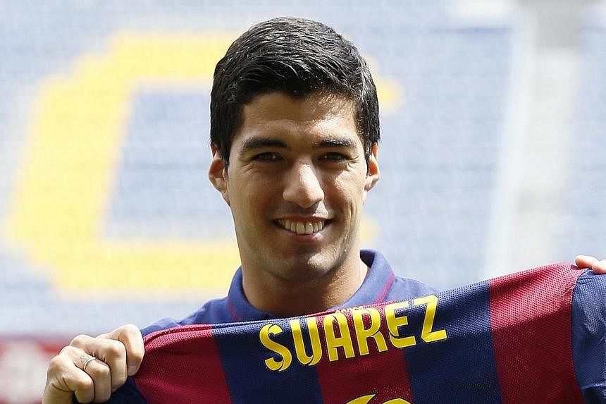 FC Barcelona's Luis Suarez holds up his jersey during his presentation at the Nou Camp stadium in Barcelona on Aug 19, 2014.&nbsp;Barcelona striker Luis Suarez said he has received professional help after receiving a four-month ban for biting an oppo