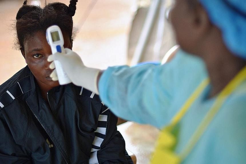 A girl suspected of being infected with Ebola has her temperature checked at a hospital in Kenema, Sierra Leone, on August 16, 2014. Vietnam is testing two Nigerians for the deadly virus after they arrived on a flight to Ho Chi Minh City showing symp