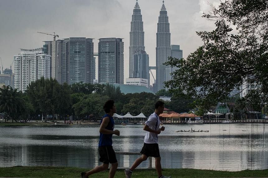 A park in Kuala Lumpur with Malaysia's Petronas Twin Towers in the backgrond on August 13, 2014. Suspected Malaysian militants loyal to the extremist Islamic State (IS) movement bought bomb-making material ahead of a proposed attack on a Carlsberg br