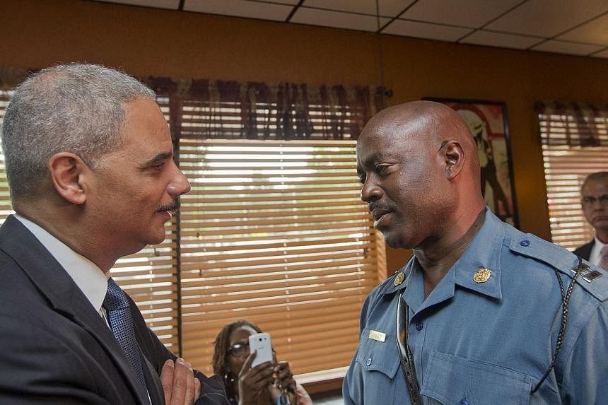 Attorney-General Eric Holder talks with Captain Ron Johnson of the Missouri State Highway Patrol at Drake's Place Restaurant in Florrissant, Missouri on Aug 20, 2014.&nbsp;Protests in the strife-torn town of Ferguson cooled late on Wednesday after th