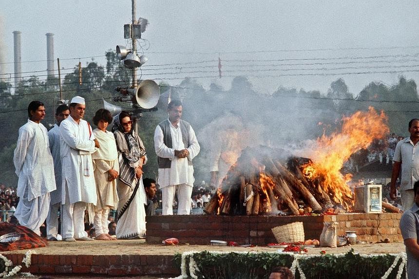 This photograph taken on Nov 3, 1984, shows India's then Premier Rajiv Gandhi (second from left), accompanied by his Italian-born wife Sonia (third from left), his daughter Priyanka (centre) and bodyguards as they stand at the cremation site of his m