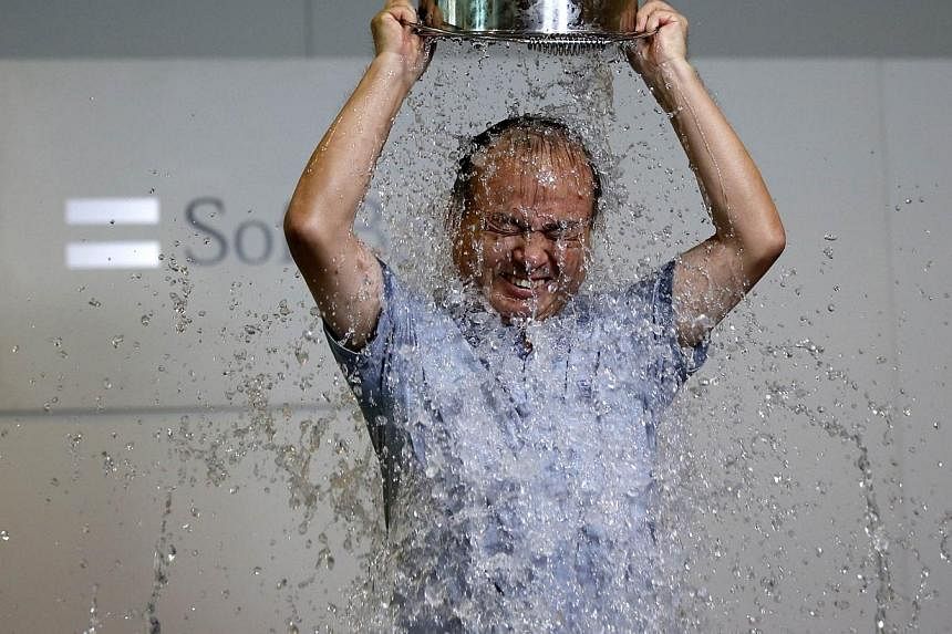SoftBank chief executive Masayoshi Son dumps a bucket of ice water onto himself as he takes part in the ALS ice bucket challenge at the company headquarters in Tokyo on Aug 20, 2014. -- PHOTO: REUTERS