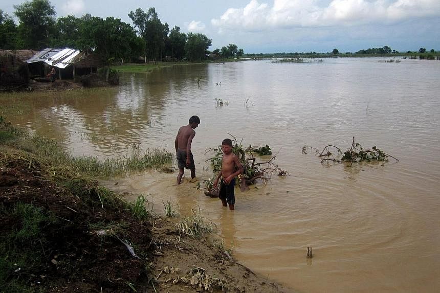 In this photograph taken on Aug 16, 2014, Nepalese villagers walk through floodwaters in the village of Holiya in Banke District some 351km west of Kathmandu.&nbsp;A United States tourist died on Thursday while trying to cross a swollen river in Nepa
