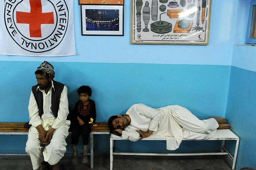 Afghan patients wait on a benches at the Internatinal Committee of Red Cross ( ICRC) hospital for war victims in Herat province on Aug 17, 2014.&nbsp;One hundred and fifty years ago to the day, the first "Geneva Convention for the Amelioration of the