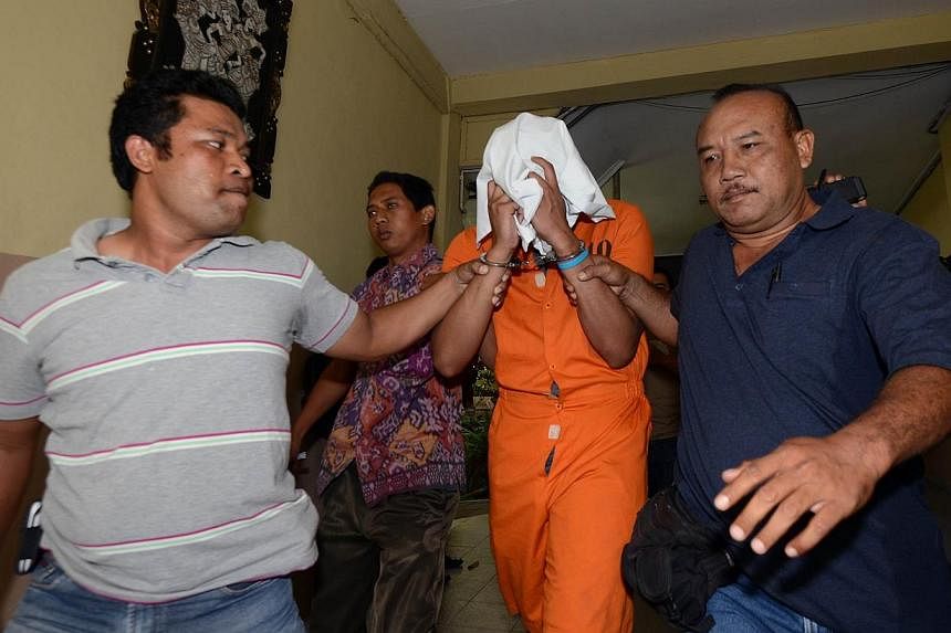 Police escort suspect Tommy Schaffer (centre), suspected in the murder of Sheila von Wiese Mack, while in custody at Bali police hospital in Denpasar on the Indonesian resort island of Bali on Aug 15, 2014. -- PHOTO: AFP