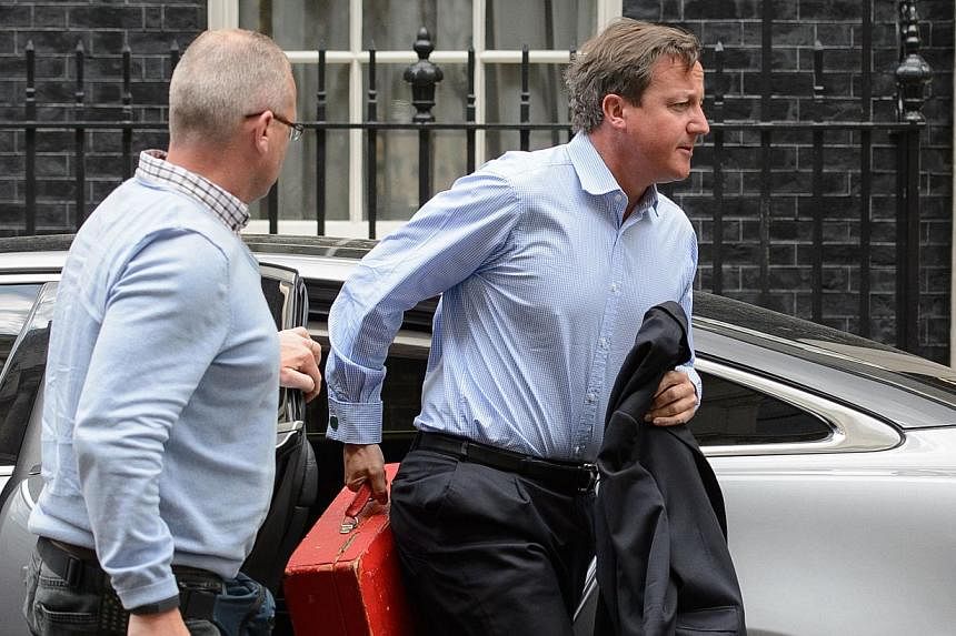 British Prime Minister David Cameron arriving back in Downing Street, central London on August 20, 2014. Cameron broke off his holiday on Wednesday for talks on the threat posed by Islamic State jihadists following the "shocking and depraved" beheadi