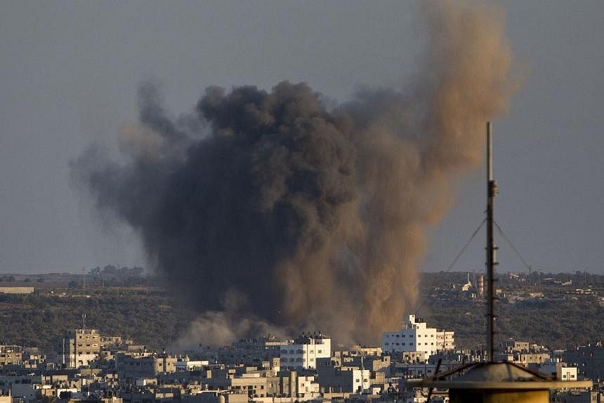 Smoke rises from buildings following an Israeli air strike on Gaza City on August 20, 2014. Israeli warplanes pounded Gaza as furious mourners buried the wife and child of Hamas' top military commander, baying for revenge as nine days of calm explode