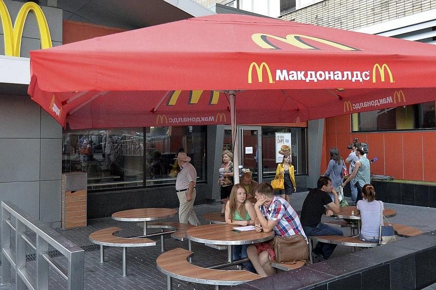 People sit outside a closed McDonald's restaurant in Moscow, August 20, 2014. Russia ordered the temporary closure of four McDonald's restaurants in Moscow on Wednesday, a decision it said was over sanitary violations but which comes against a backdr