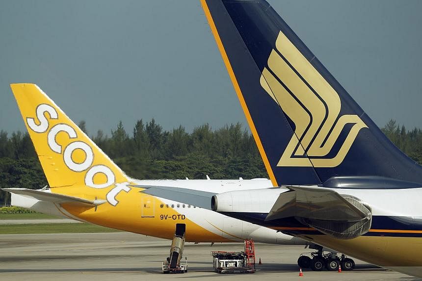 A Scoot and a Singapore Airlines (SIA) plane at Changi Airport Terminal 2. -- ST PHOTO: LIM WUI LIANG