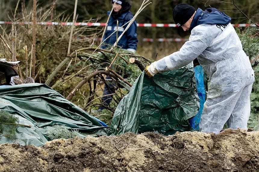 Policemen search for evidence at the area where body parts were found on Nov 29, 2013 in Reichenau, eastern Germany. A German police officer will go on trial on Aug 22, 2014, accused of murdering a volunteer he met on a website for cannibalism fetish