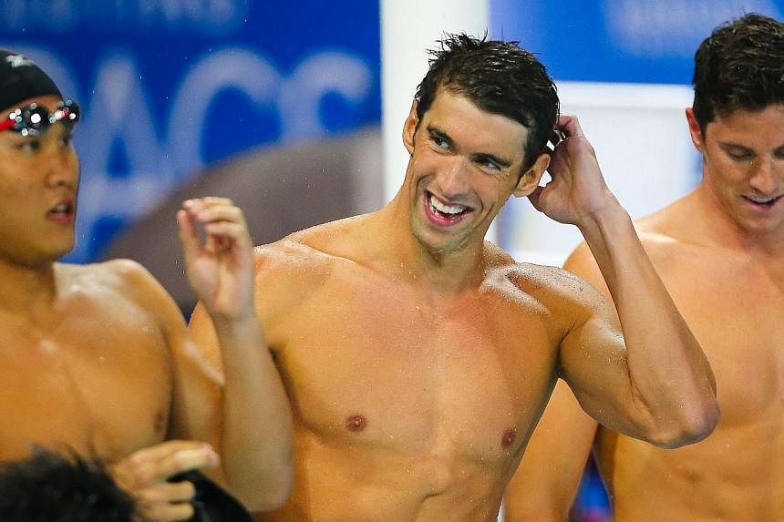 Yuki Kobori (left) of Japan and Michael Phelps (centre) of the US react after the men's 4x200m freestyle relay final at the Gold Coast Aquatic Centre, Gold Coast on Aug 22, 2014.&nbsp;-- PHOTO: AFP&nbsp;