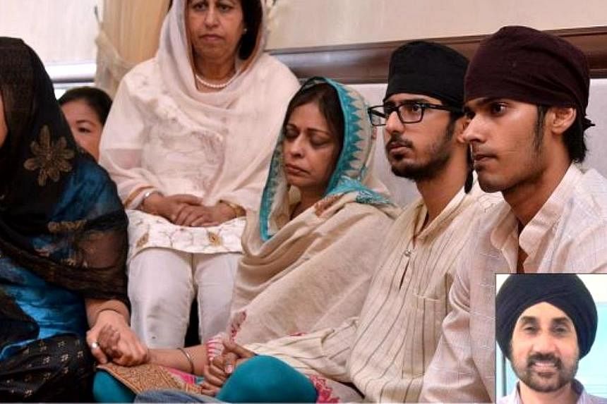 (From right) Melvinderjit, Amarpal and Harbinder, along with relatives and friends at the paath da bhog for Karamjit Singh (inset) at Gurdwara Sahib Pulapol. -- PHOTO: THE STAR/ASIA NEWS NETWORK