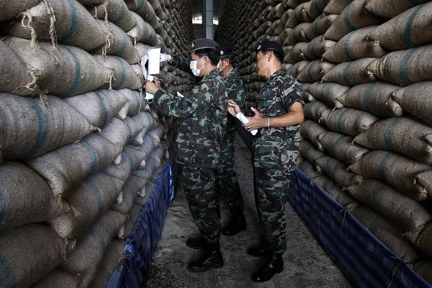 Soldiers checking sacks of rice at a warehouse in Ayutthaya province, north of Bangkok, on July 3, 2014.&nbsp;One of the first measures Thailand’s military regime took after seizing power on May 22 was to pay millions of rice farmers money owed to 