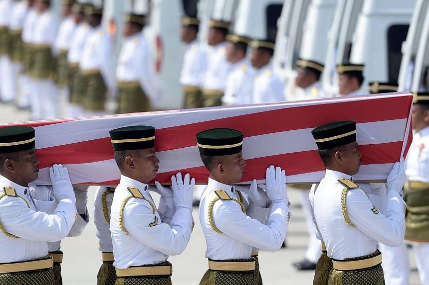 Soldiers carry a coffin with the remains of a Malaysian victim from the Malaysia Airlines flight MH17 that crashed in Ukraine during a ceremony at the Bunga Raya complex at Kuala Lumpur International Airport in Sepang on Aug 22, 2014. -- PHOTO: AFP