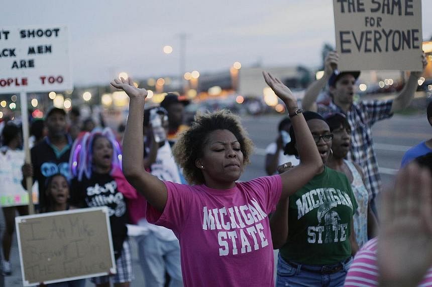 Demonstrators protest the shooting of Michael Brown on Aug 22, 2014 in Ferguson, Missouri. A police officer in Missouri was suspended on Friday after he voiced his contempt via Facebook of protesters condemning the fatal shooting of the black teenage