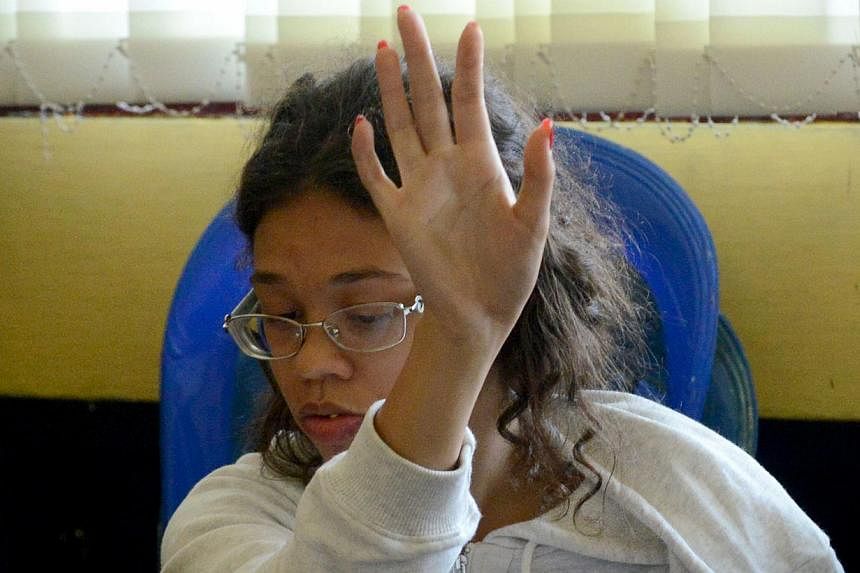 Heather Mack, suspected in the murder of her mother Sheila von Wiese Mack, gestures while in custody at a police station in Denpasar on the Indonesian resort island of Bali on Aug 14, 2014. -- PHOTO: AFP