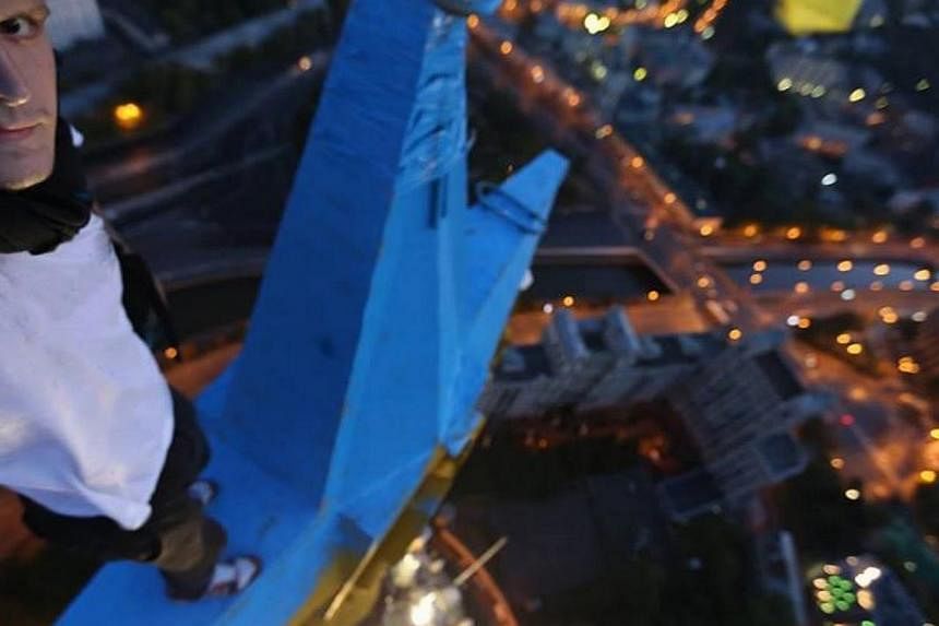 A renowned Ukrainian extreme sportsman said he scaled a landmark Moscow skyscraper and painted a star at the top of the building in the blue-and-yellow colours of the Ukrainian national flag in a burst of patriotic feeling. -- PHOTO: MUSTANG WANTED/F