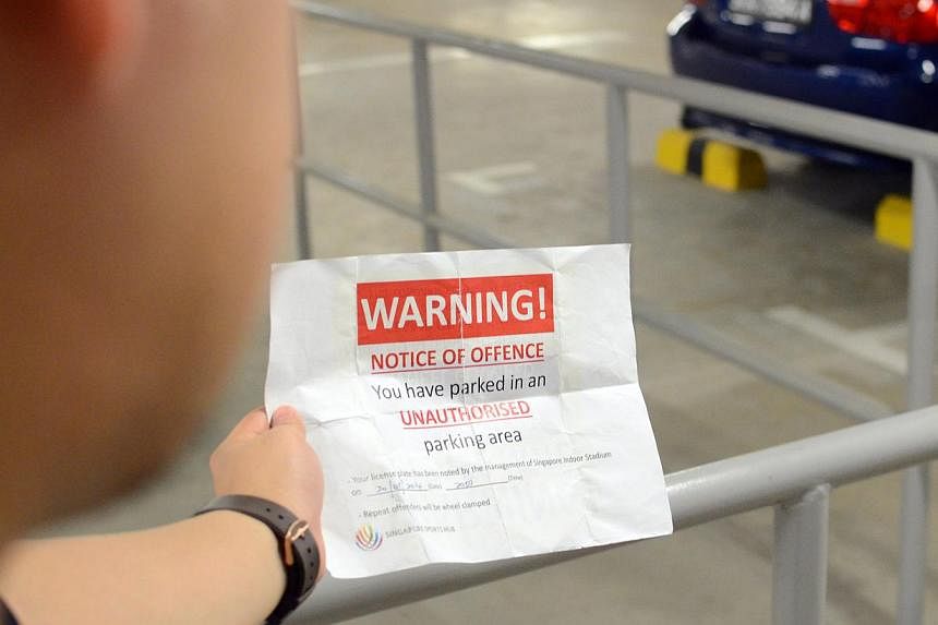 Mr Relucio holding up the warning letter that was taped to his bicycle on Wednesday night. The retail worker had chained his bicycle to a carpark railing at the Sports Hub because no bicycle rack was available.