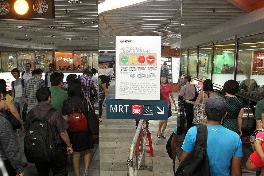 The peak-hour crowd heading into Tanjong Pagar MRT station after work as the amber light indicates a slightly crowded platform, meaning a possible wait of two trains. A trial of the system was conducted at Tanjong Pagar station in January.