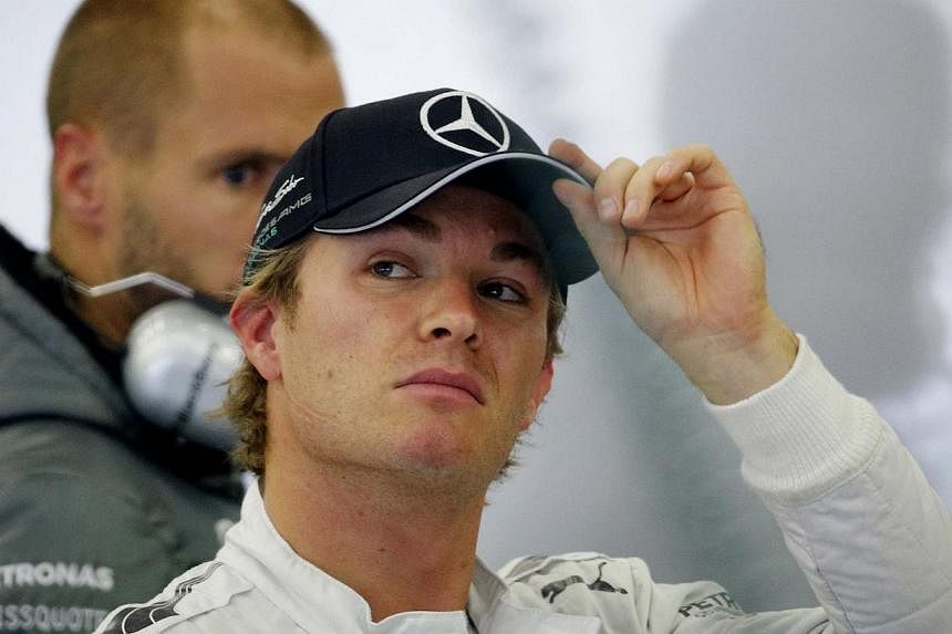 Mercedes Formula One driver Nico Rosberg of Germany adjusts his cap during a practice session at the Belgian F1 Grand Prix in Spa-Francorchamps on Aug 23, 2014. -- PHOTO: REUTERS