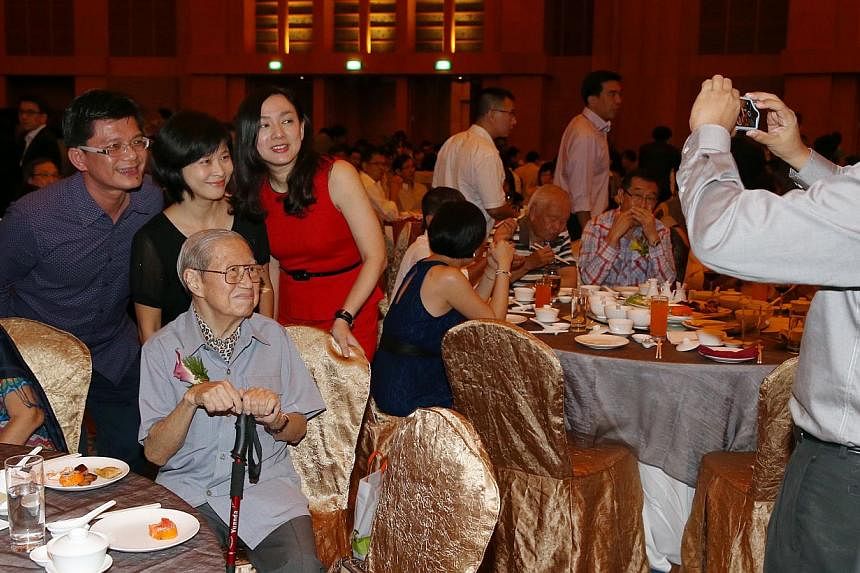 Hwa Chong Junior College alumni (standing, from left) Tan Jui Chai, 47, Soh Wai Lan, 47, and Kuah Boon Theng, 47, taking a photo with Hwa Chong's ex-principal Bernard Fong, 84 (seated), at the school's 40th anniversary gala dinner, which was held at 