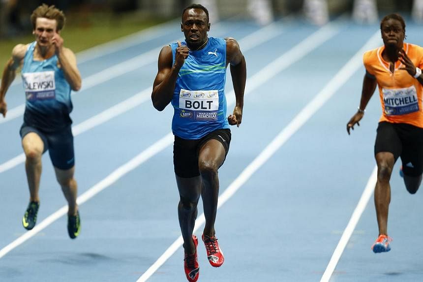 Usain Bolt of Jamaica (C), Poland's Karol Zalewski (L) and Sheldon Mitchell of Jamaica compete in the men's 100m race.&nbsp;Jamaican sprint superstar Usain Bolt set a new best time of 9.98sec for the rarely run 100m indoors at Warsaw's national footb