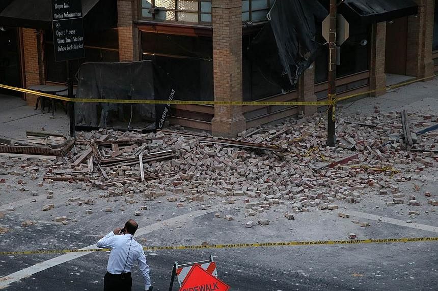 A reporter surveys the scene of a building collapse following a 6.1 earthquake on Aug 24, 2014, in Napa, California.&nbsp;Dozens of people were injured, two of them seriously, when a 6.1 magnitude earthquake hit the city of Napa in the wine-producing