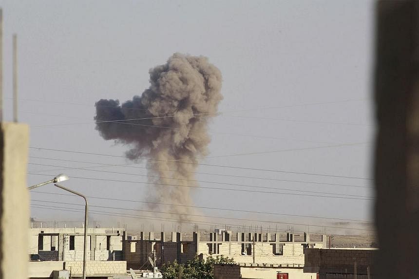 Smoke rises during what activists said was an air raid by warplanes operated by forces of Syria's President Bashar Al-Assad around al-Tabqa military base at a government-controlled airport that is surrounded by militants, west of Raqa city, on Aug 21
