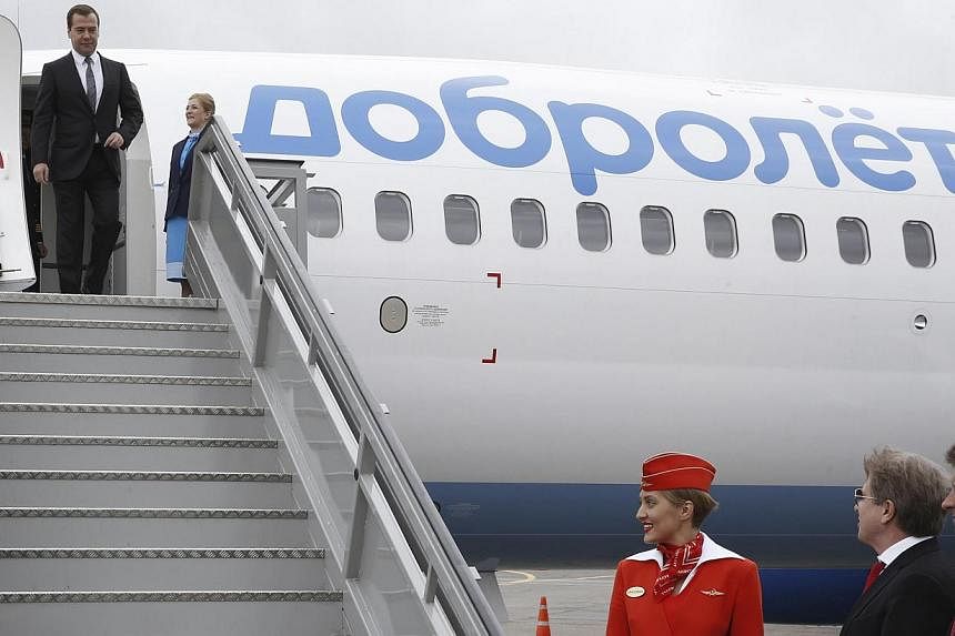 Russian Prime Minister Dmitry Medvedev (top) inspects a Boeing 737-800 NG, owned by Dobrolyot airline, with Minister of Transport Maxim Sokolov (right, bottom) and Aeroflot CEO and director-general Vitaly Savelyev (second right, bottom), at Sheremety