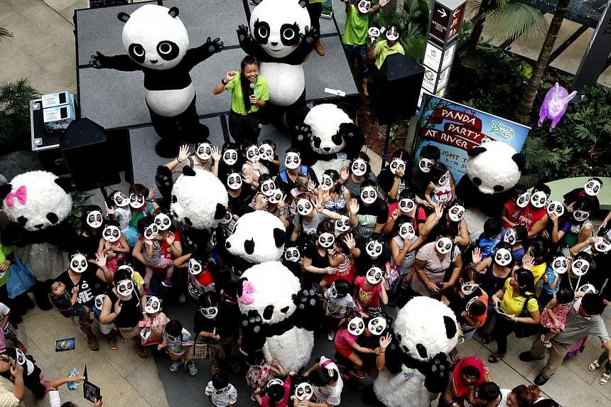 A flash mob wearing panda masks or dressed in panda suits descended on the Westgate shopping mall on Sunday in a panda parade to prod the public to preserve the environment. -- ST PHOTO:&nbsp;CHEW SENG KIM