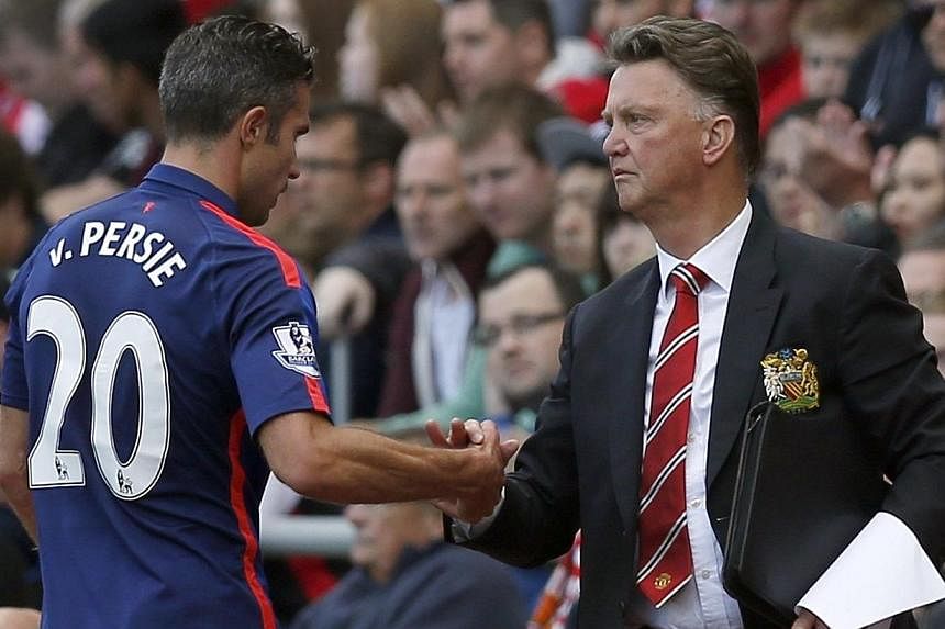 Manchester United manager Louis Van Gaal (right) shakes hands with striker Robin Van Persie after substituting him during their English Premier League football match against Sunderland at the Stadium of Light in Sunderland, northern England on Aug 24
