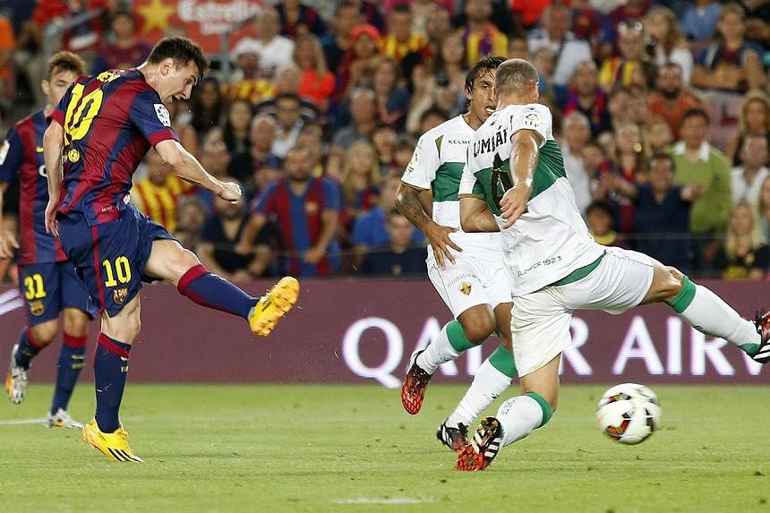 Barcelona's Lionel Messi (left) scores a goal against Elche during the Spanish first division match at Nou Camp stadium in Barcelona on Aug 24, 2014. -- PHOTO: REUTERS