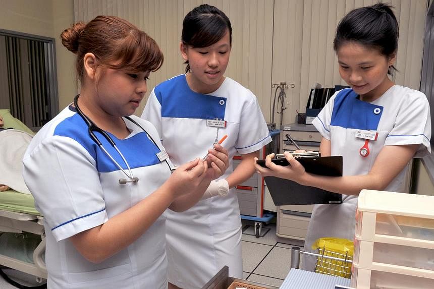 Nursing students from Nanyang Polytechnic making preparations in a simulation lab at their school. -- PHOTO: ST FILE