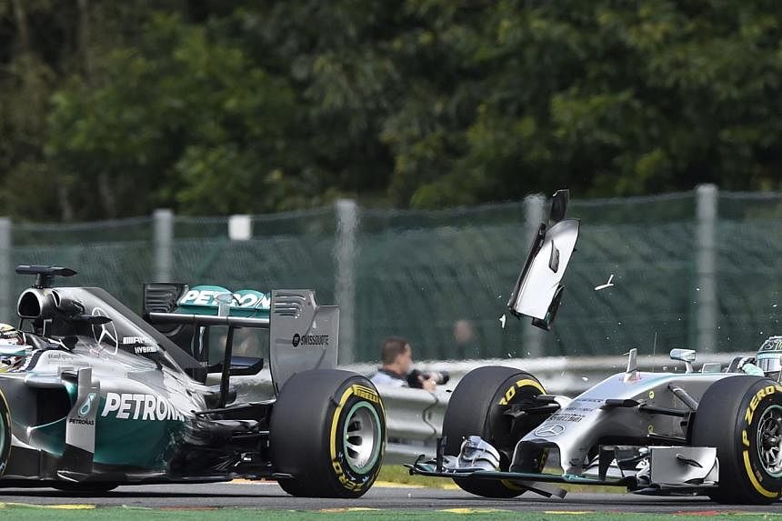 Mercedes-AMG's British driver Lewis Hamilton (left) and and Mercedes-AMG's German driver Nico Rosberg collide at the Spa-Francorchamps ciruit in Spa on August 24, 2014 during the Belgium Formula One Grand Prix. -- PHOTO: AFP&nbsp;