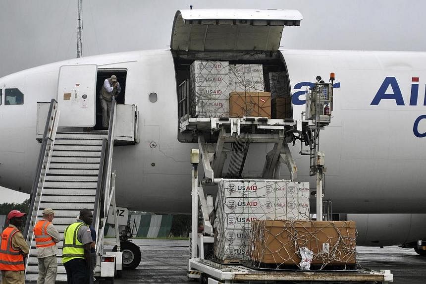 Workers are seen waiting to unload the first consignment of US Agency for International Development (USAID) medical equipment towards the fight against Ebola at the Roberts International Airport in Monrovia on Aug 24, 2014. Protective equipment for m