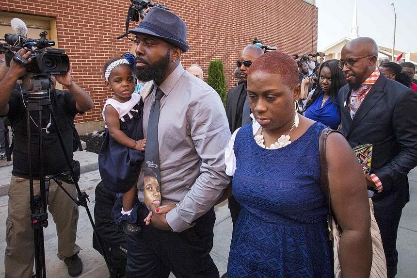 Lesley McSpadden (right) and Michael Brown Sr (left), parents of 18-year-old Michael Brown, arrive to take part in their son's funeral service at the Friendly Temple Missionary Baptist Church in St Louis, Missouri, August 25, 2014. Brown, an unarmed 