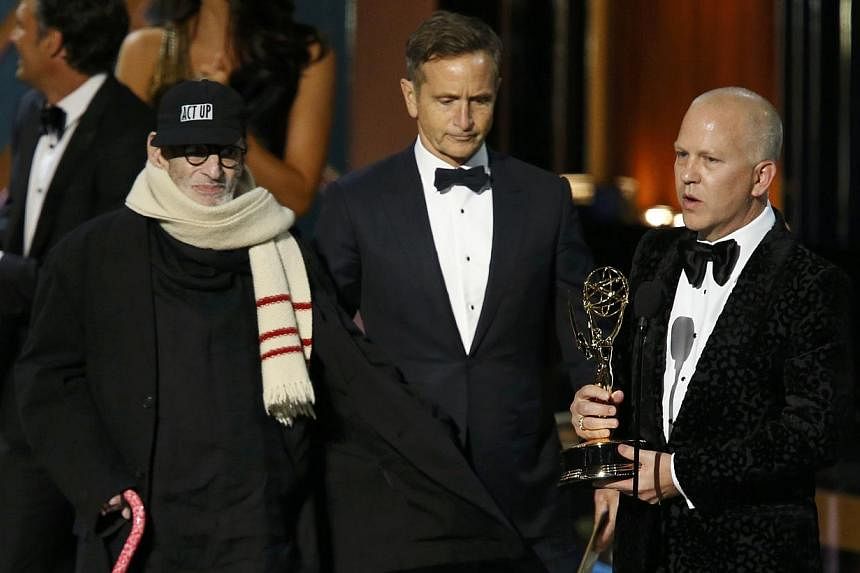 Executive producer Ryan Murphy (right) accepting the award for Outstanding Television Movie for The Normal Heart, with playwright Larry Kramer (left) onstage during the 66th Primetime Emmy Awards in Los Angeles. -- PHOTO: REUTERS