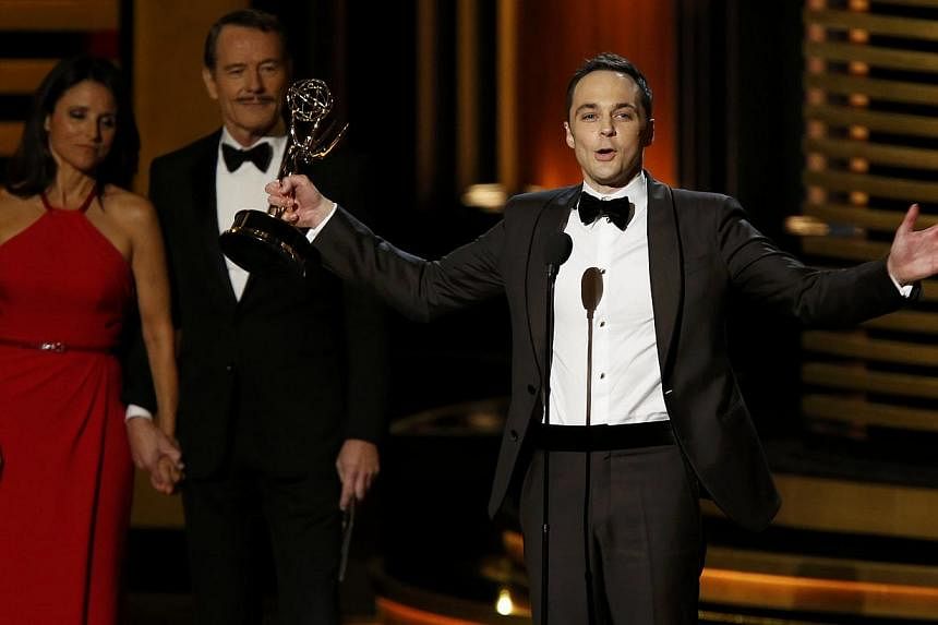 Jim Parsons accepts the award for Outstanding Lead Actor In A Comedy Series for his role in The Big Bang Theory as presenters Julia-Louis Dreyfus and Bryan Cranston look on during the 66th Primetime Emmy Awards in Los Angeles, California on Aug 25, 2