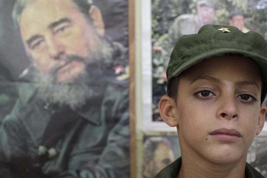 Eight-year-old Marlon Mendez, who claims to be an admirer of Cuba's former president Fidel Castro, poses in his military costume inside his bedroom that is adorned with pictures of Castro, in San Antonio de los Banos outside Havana City August 13, 20