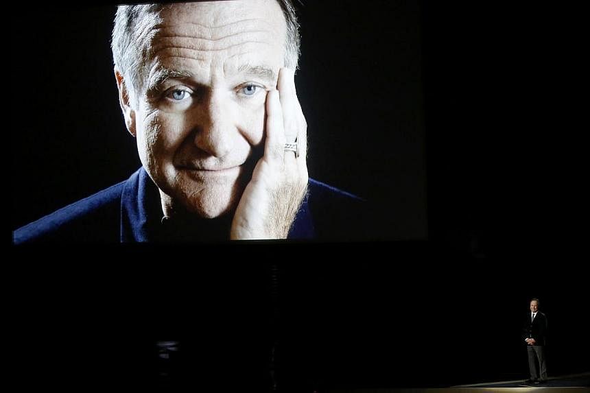 Billy Crystal takes the stage to pay tribute to the late Robin Williams, shown on a large screen, during the 66th Primetime Emmy Awards in Los Angeles, California on Aug 25, 2014. -- PHOTO: REUTERS