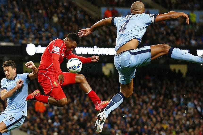 Liverpool's Daniel Sturridge (centre) is challenged by Manchester City's Martin Demechelis (left) and Vincent Kompany during their English Premier League soccer match at the Etihad stadium in Manchester, northern England August 25, 2014. -- PHOTO: RE