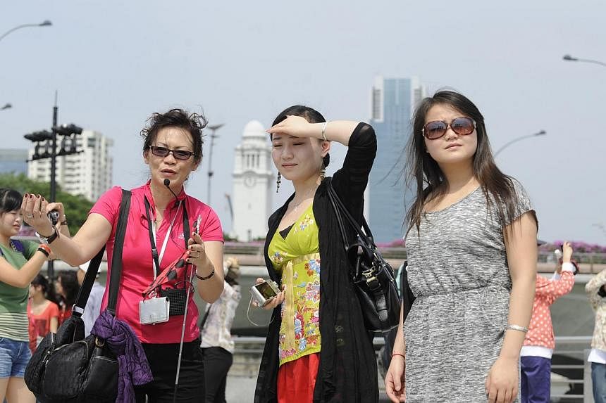 A tour guide (left) speaking to tourists from China while on a tour in Singapore. -- PHOTO: ST FILE