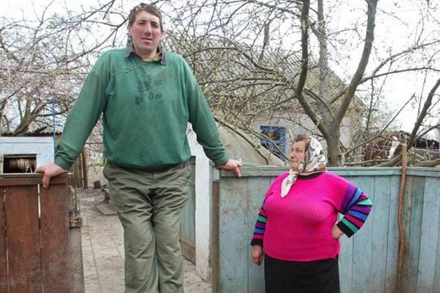 Olena Stadnyk (right) looking up at her son Leonid, who died on Sunday of a cerebral haemorrhage.&nbsp;Stadnyk, 44, reached almost 2.6m due to a tumorous gland that continued to secrete growth hormones throughout his life and died due to complication