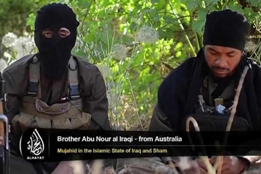 An Islamist fighter, identified as Abu Nour al-Iraqi from Australia (left), speaks in this still image taken from an undated video shot at an unknown location and uploaded to a social media website on June 19, 2014.&nbsp;Fifteen Australians, includin