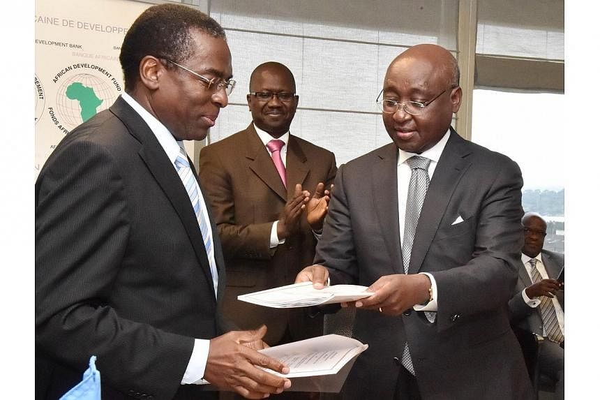 African Development Bank president Donald Kaberuka (right) and World Health Organisation regional director for Africa Luis G. Sambo (left) exchange documents after agreeing on a donation of US$60 million (S$75 million) to fight the Ebola virus on Aug