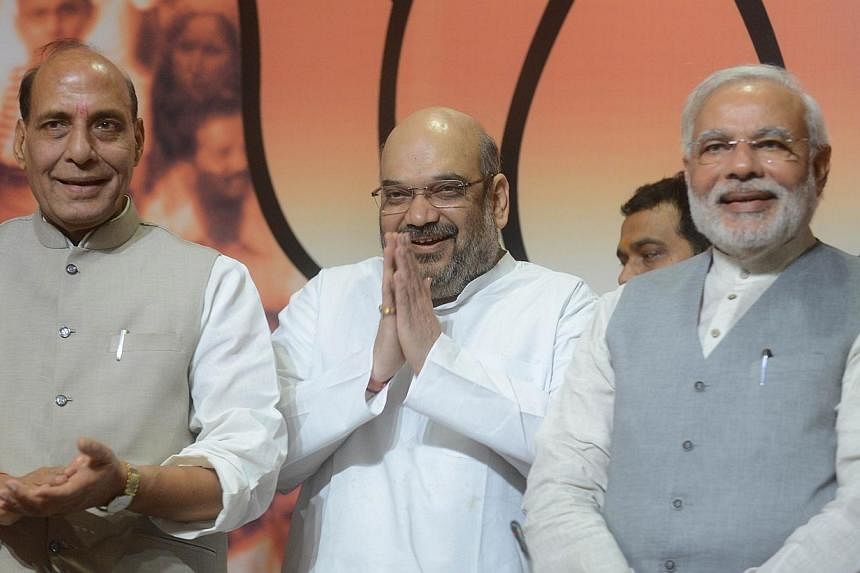 Indian Home Minister and former Bharatiya Janata Party (BJP) president, Rajnath Singh (left), new Bharatiya Janata Party (BJP) president Amit Shah (centre) and Indian Prime Minister Narendra Modi pose during the appointment of the party's president i