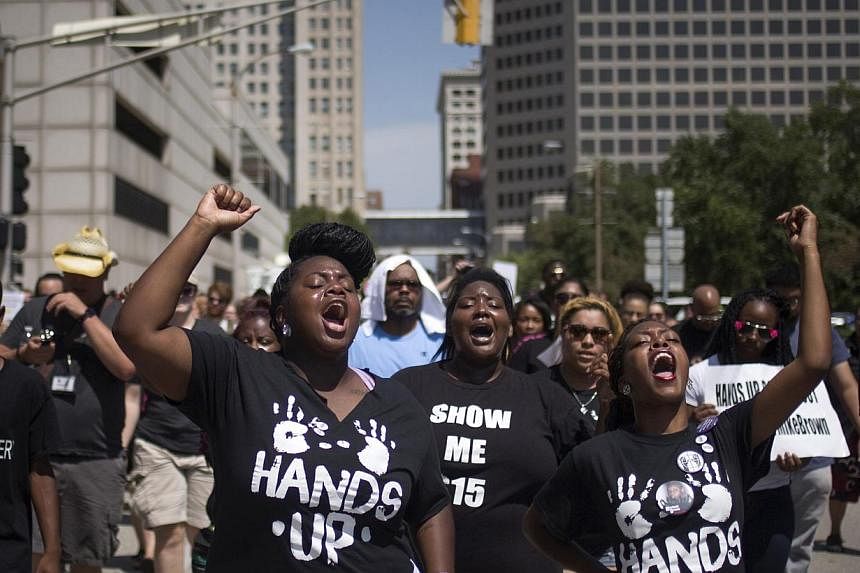Activists raise their hands as they demand justice for the killing of Michael Brown while marching to the Thomas F. Eagleton United States Courthouse from City Hall in downtown St Louis, Missouri on Aug 26, 2014.&nbsp;-- PHOTO: REUTERS