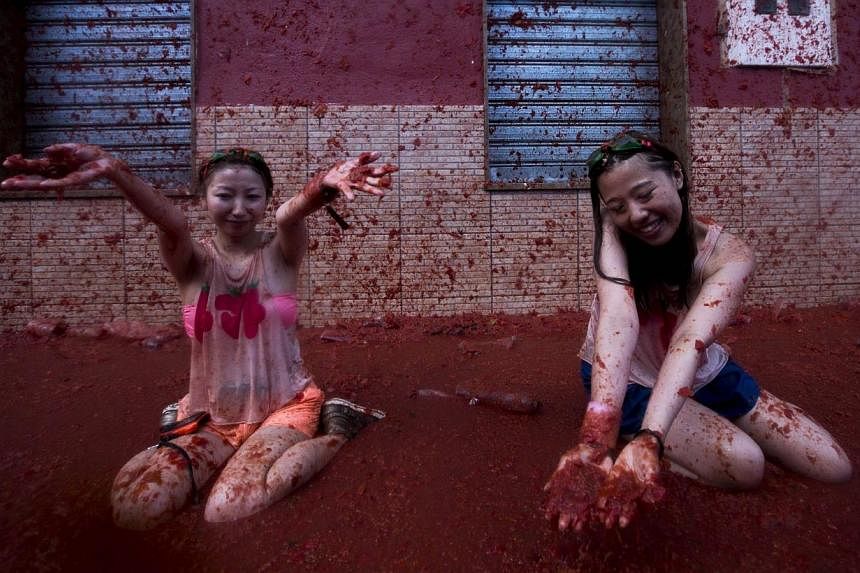 Revellers take part in the annual "tomatina" festivities in the village of Bunol, near Valencia on Aug 28, 2013.&nbsp;Half-naked revellers pelted each other with tomatoes and bathed in red goo on Wednesday, Aug 27, 2014, in Spain's Tomatina, a fiesta